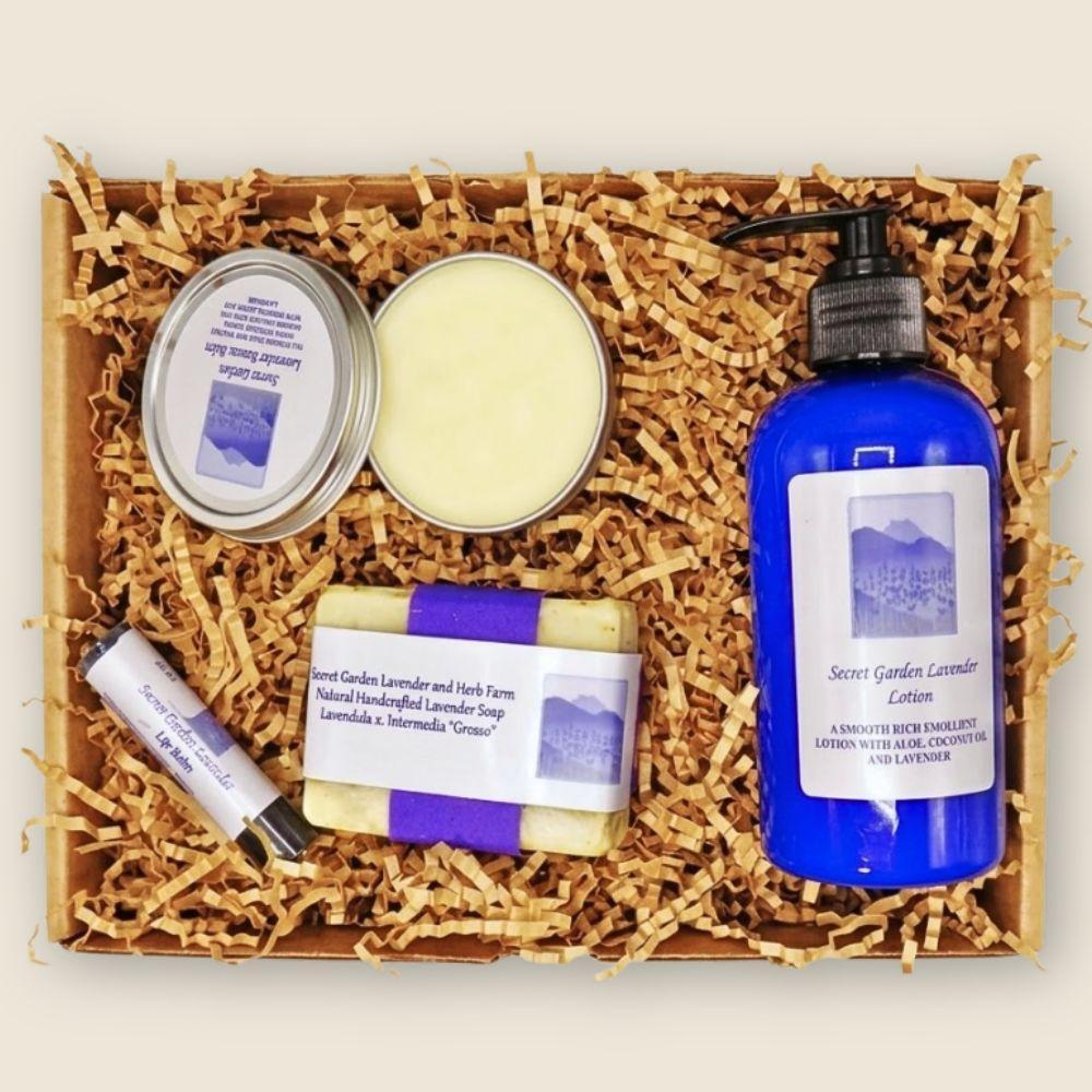 Set of lavender-themed products including lotion, soap, and other items in a box with crinkled paper.
