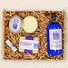 Set of lavender-themed products including lotion, soap, and other items in a box with crinkled paper.