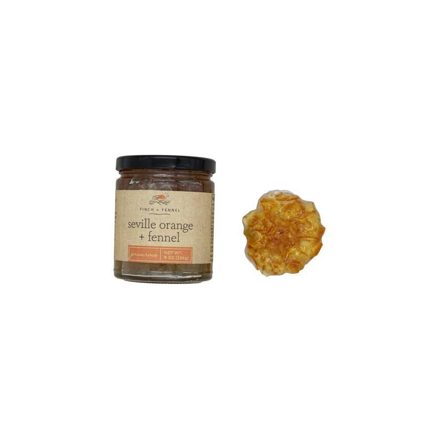 Jar of seville orange and fennel spread with a sample on a white background