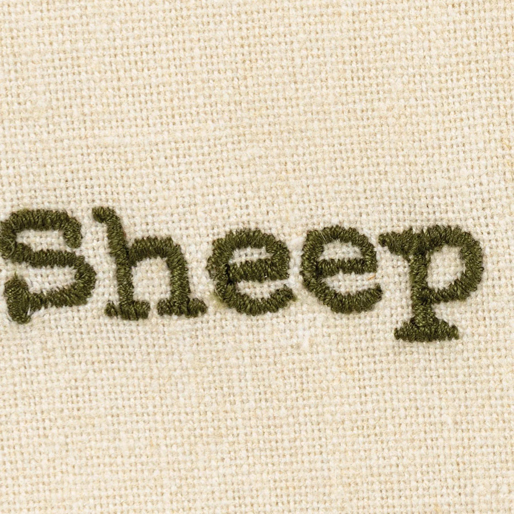 Text 'Sheep' embroidered on a beige fabric background
