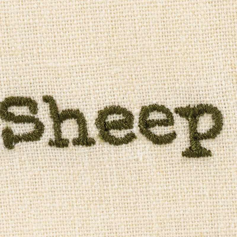 Text 'Sheep' embroidered on a beige fabric background