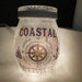 Decorative glass jar with 'Coastal Travels' design featuring a compass and anchors.