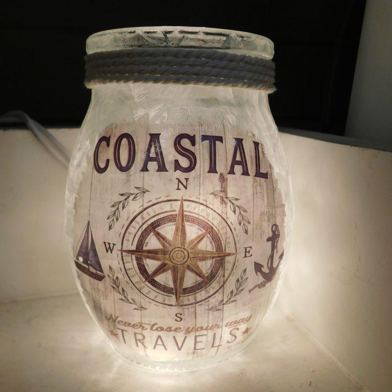 Decorative glass jar with 'Coastal Travels' design featuring a compass and anchors.
