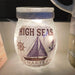 Decorative jar with 'High Seas Charter' text and nautical graphics on a light background