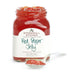 Jar of Stonewall Kitchen Red Pepper Jelly with a spoonful of jelly on a white background