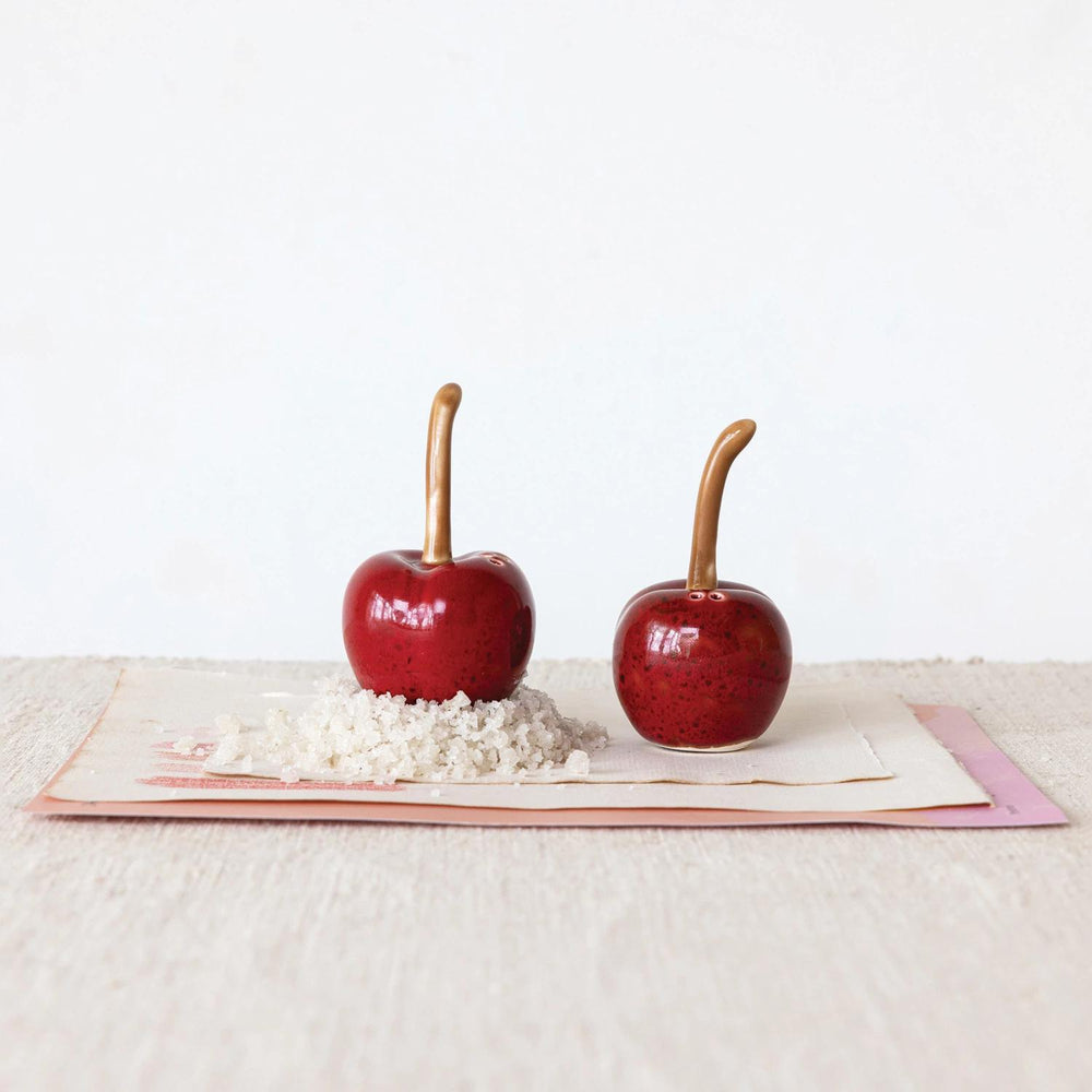 Two red candy apples on a white surface with a white background