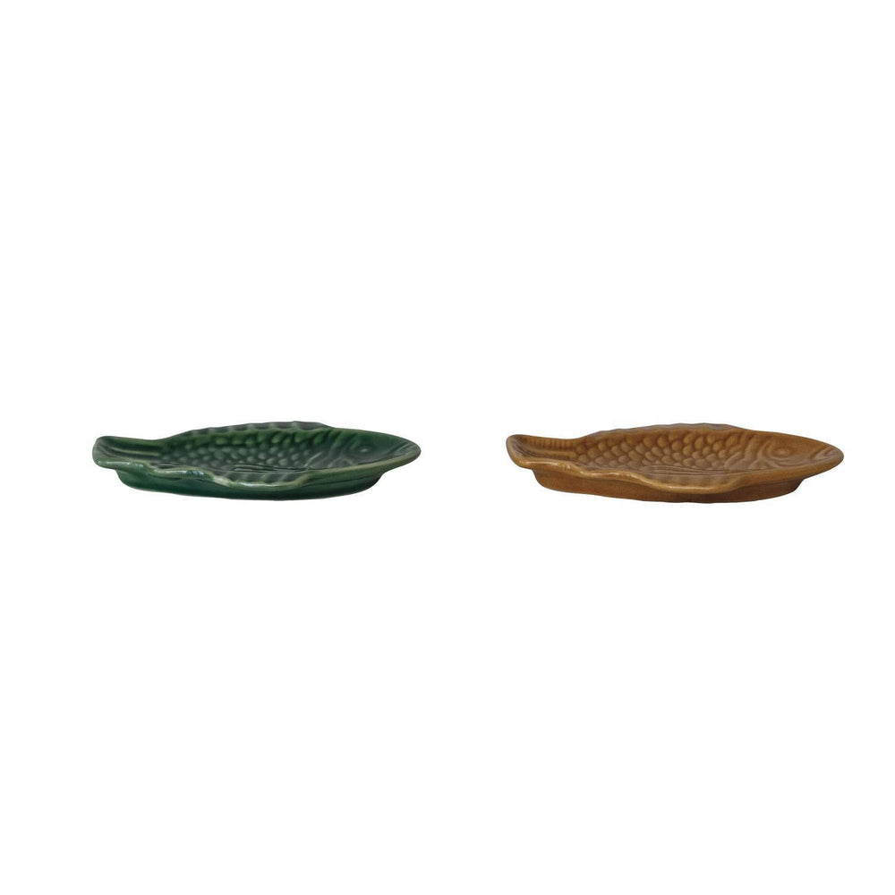 Two ceramic leaf-shaped trays, one green and one brown, on a white background.
