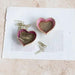 Heart-shaped containers with paper clips on a piece of paper