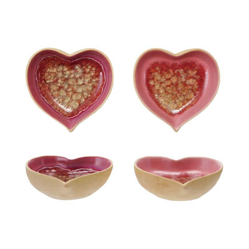 Set of four heart-shaped ceramic bowls with a pink and gold interior on a white background