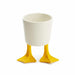 White cup with yellow feet on a white background