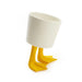 White cup with yellow duck-like feet on a white background