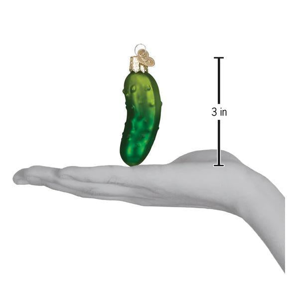 Green pickle ornament on a hand with a measurement label indicating its size.