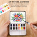 Portable watercolor kit with a floral painting on a wooden surface
