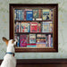Dog looking at a framed mosaic of books on a wall with floral pattern
