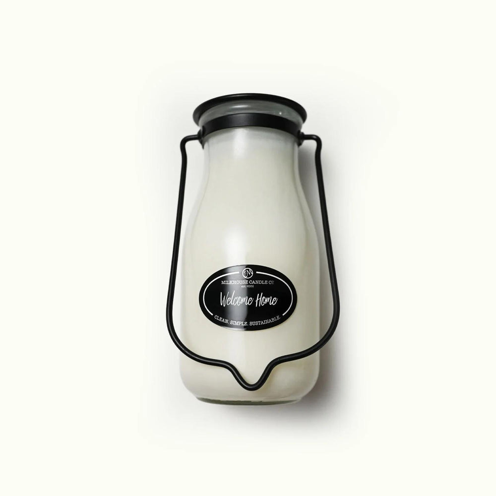 Milk bottle-shaped candle with a label on a white background
