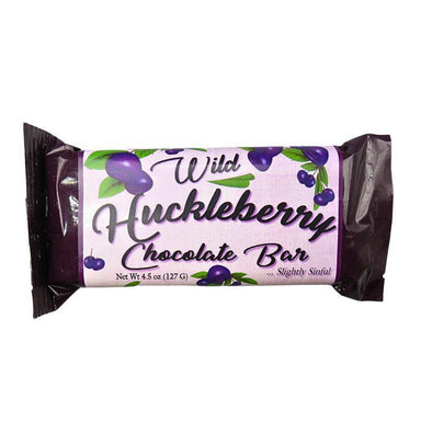 A packaged chocolate bar wrapped in dark purple foil with a white label that reads 'Wild Huckleberry Chocolate Bar' and shows purple huckleberry illustrations, on a plain white background.