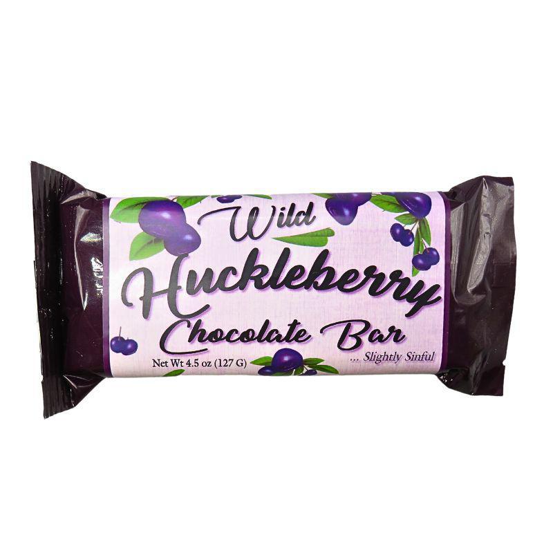 A packaged chocolate bar wrapped in dark purple foil with a white label that reads 'Wild Huckleberry Chocolate Bar' and shows purple huckleberry illustrations, on a plain white background.