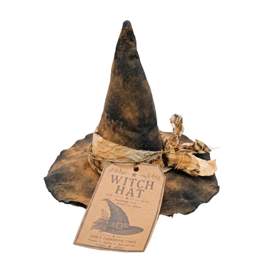 A rustic, distressed black and brown witch hat with a matching paper tag and ribbon, photographed on a clean white background.
