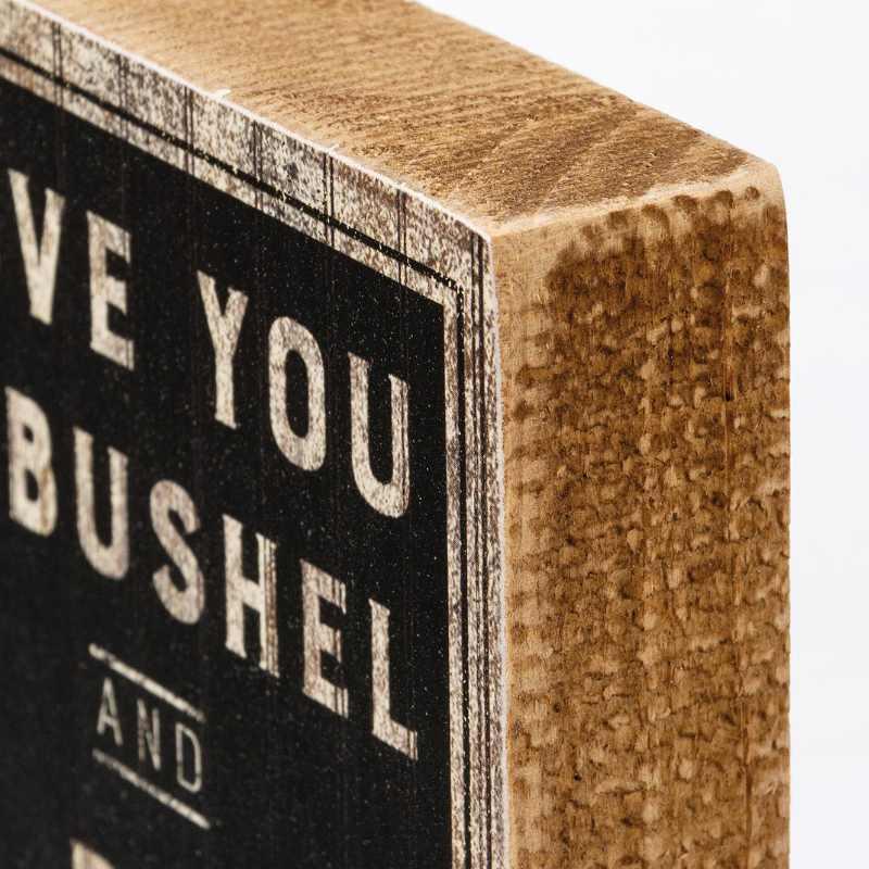 Wooden block with text 'I love you a bushel and a peck' on a white background