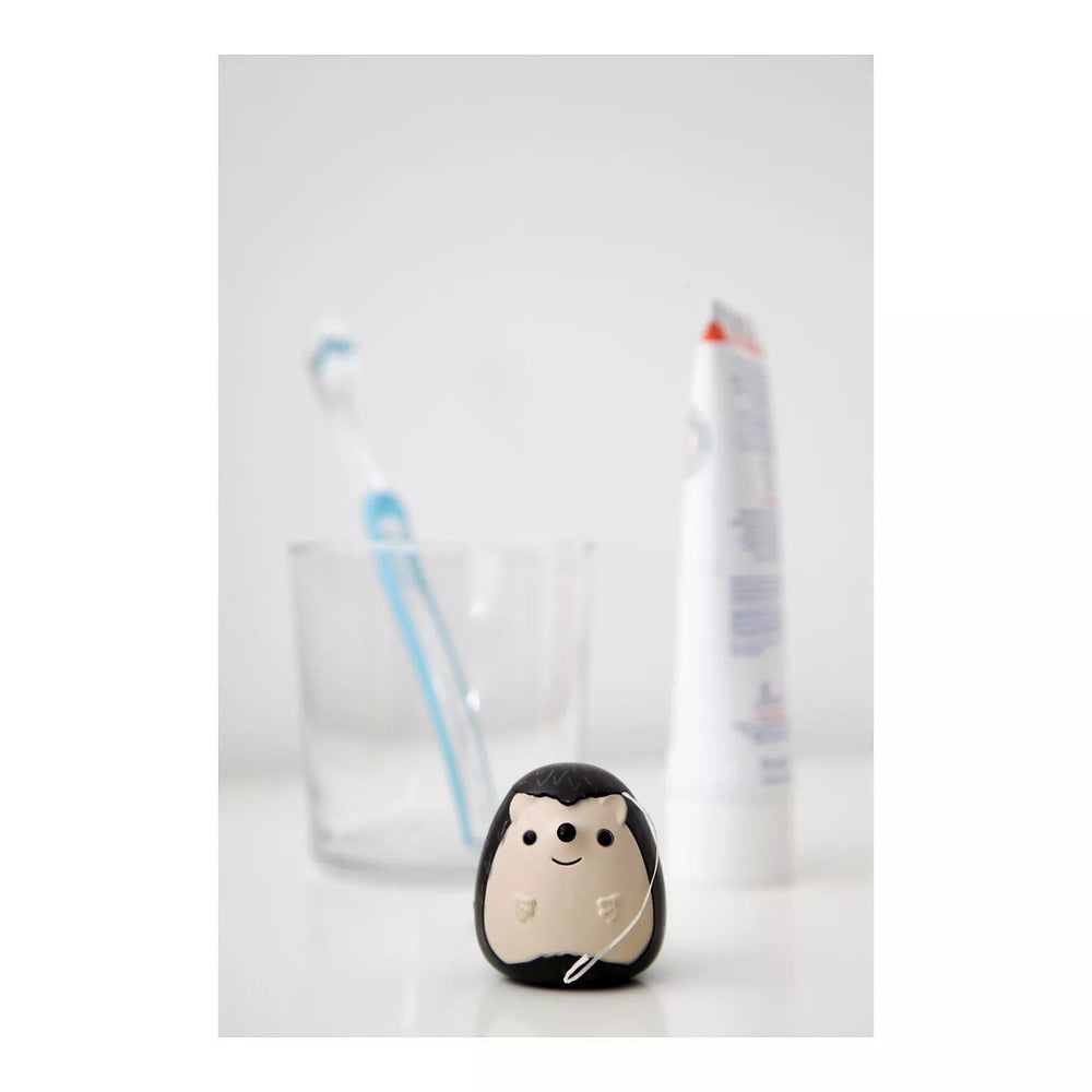 Hedgehog-shaped toothbrush holder with two toothbrushes on a white background