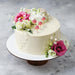 White cake with floral decorations on a gray surface