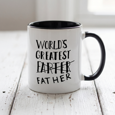 White mug with black interior and handle featuring the text 'World's Greatest Father' on a light wooden surface.
