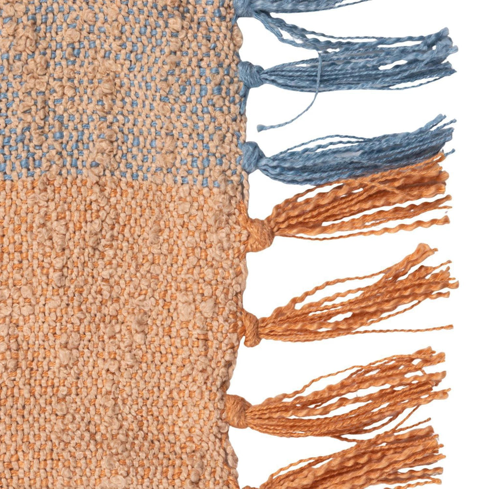 Textured fabric with blue and orange tassels on a white background