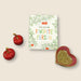 Heart-shaped dish with a green interior, two red cherry-shaped salt and pepper containers, and a book with 'You Are My Favorite Person' text on a beige background.