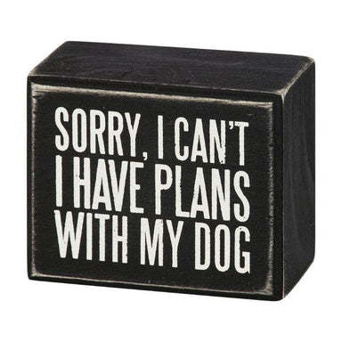 Black wooden block with white text 'Sorry, I can't. I have plans with my dog' on a white background