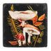 Decorative coaster with mushrooms and leaves on a black background