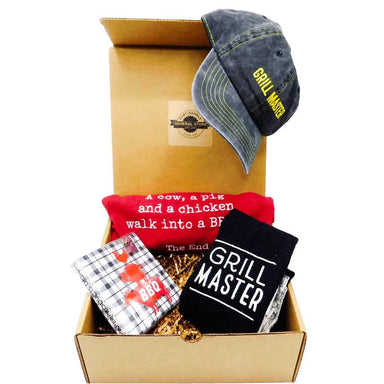 Grill Master gift set containing a grill master chef boa, a funny BBQ apron, a grill master cap, and a package of BBQ paper napkins