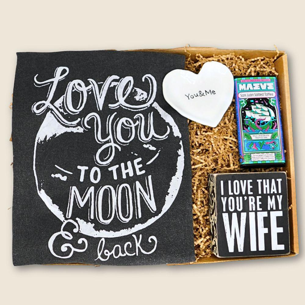 Gift set with 'Love You to the Moon & Back' card, heart-shaped item, and 'I Love That You're My Wife' sign.
