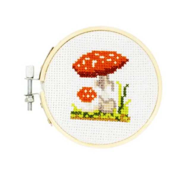 mini cross stich embroidery  showing 2 red mushrooms  with white spots and greenery 