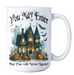 A white ceramic mug with a Halloween-themed graphic print featuring a haunted house, pumpkins, bats, a ghost, and the text 'You May Enter But You Will Never Leave!'.