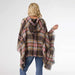 Person wearing a plaid poncho with a hood on a white background