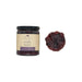 Jar of triple berry preserve with a single berry on a white background